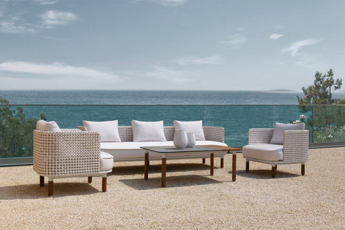 Outdoor patio set with ocean view and clear sky.